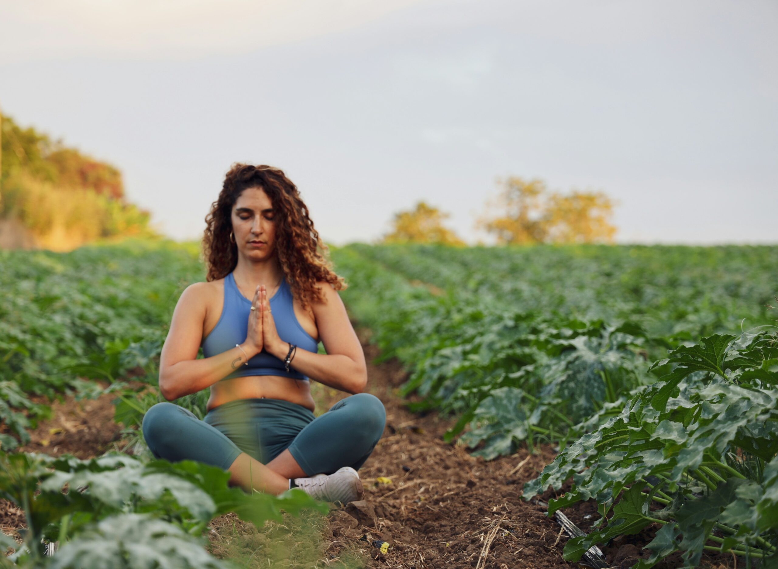 A person sitting cross-legged looking stressed while surrounded by thought bubbles