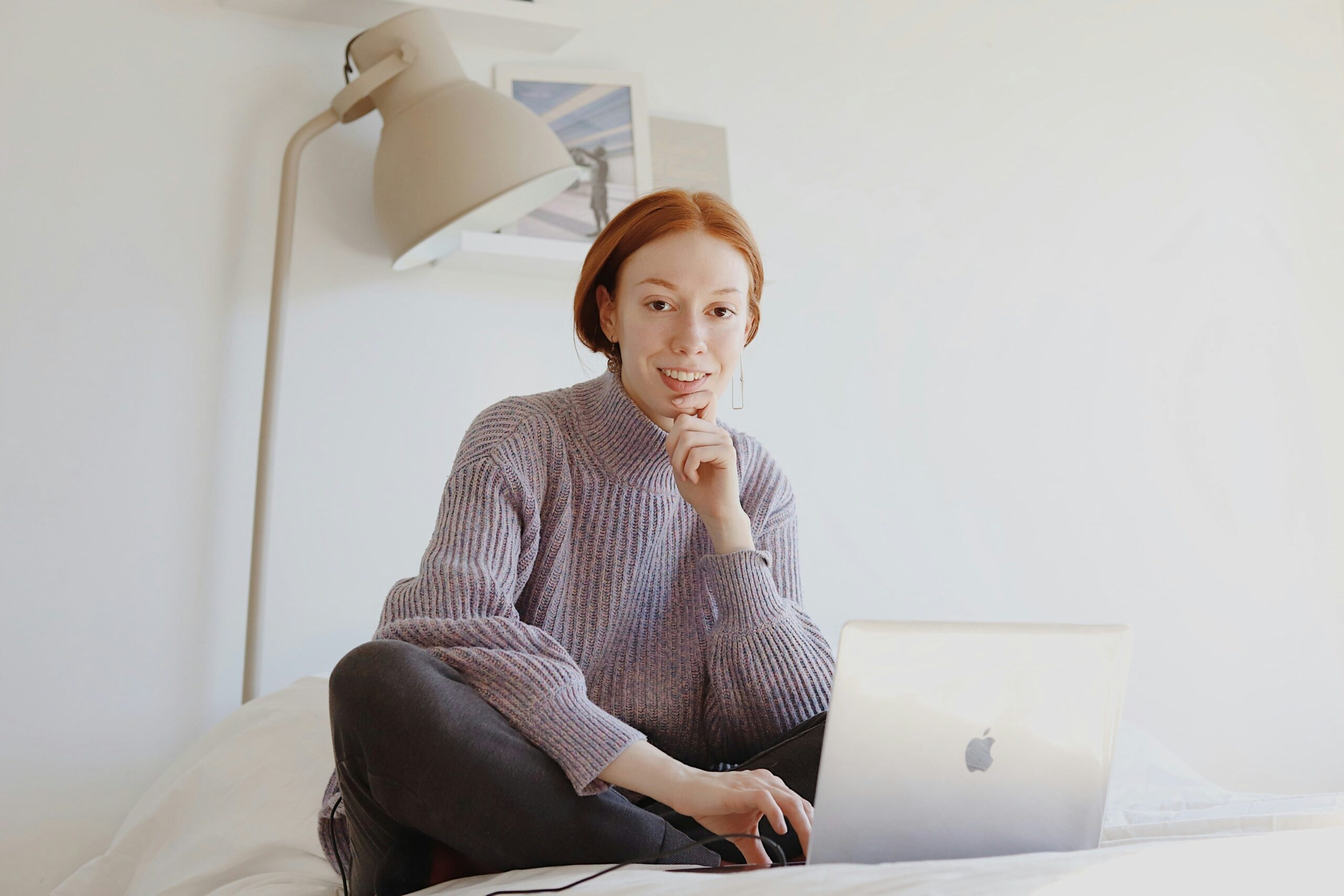 Woman looking stressed at laptop while trying to meditate