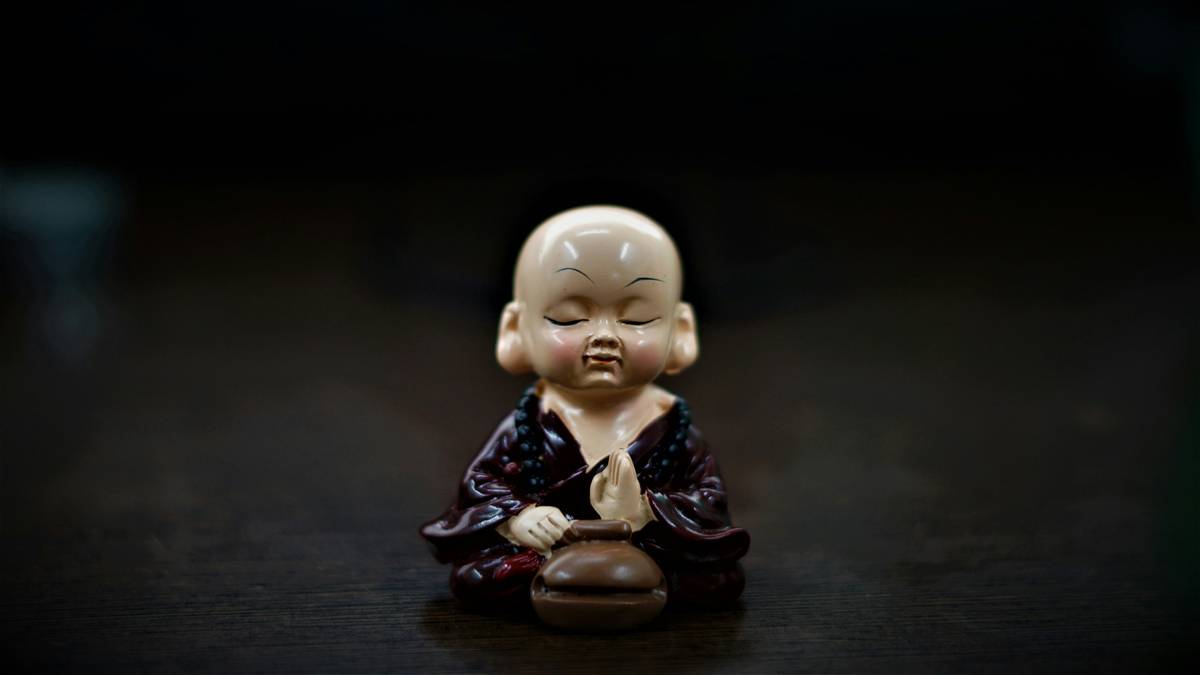 A person looking stressed while attempting meditation at their desk.