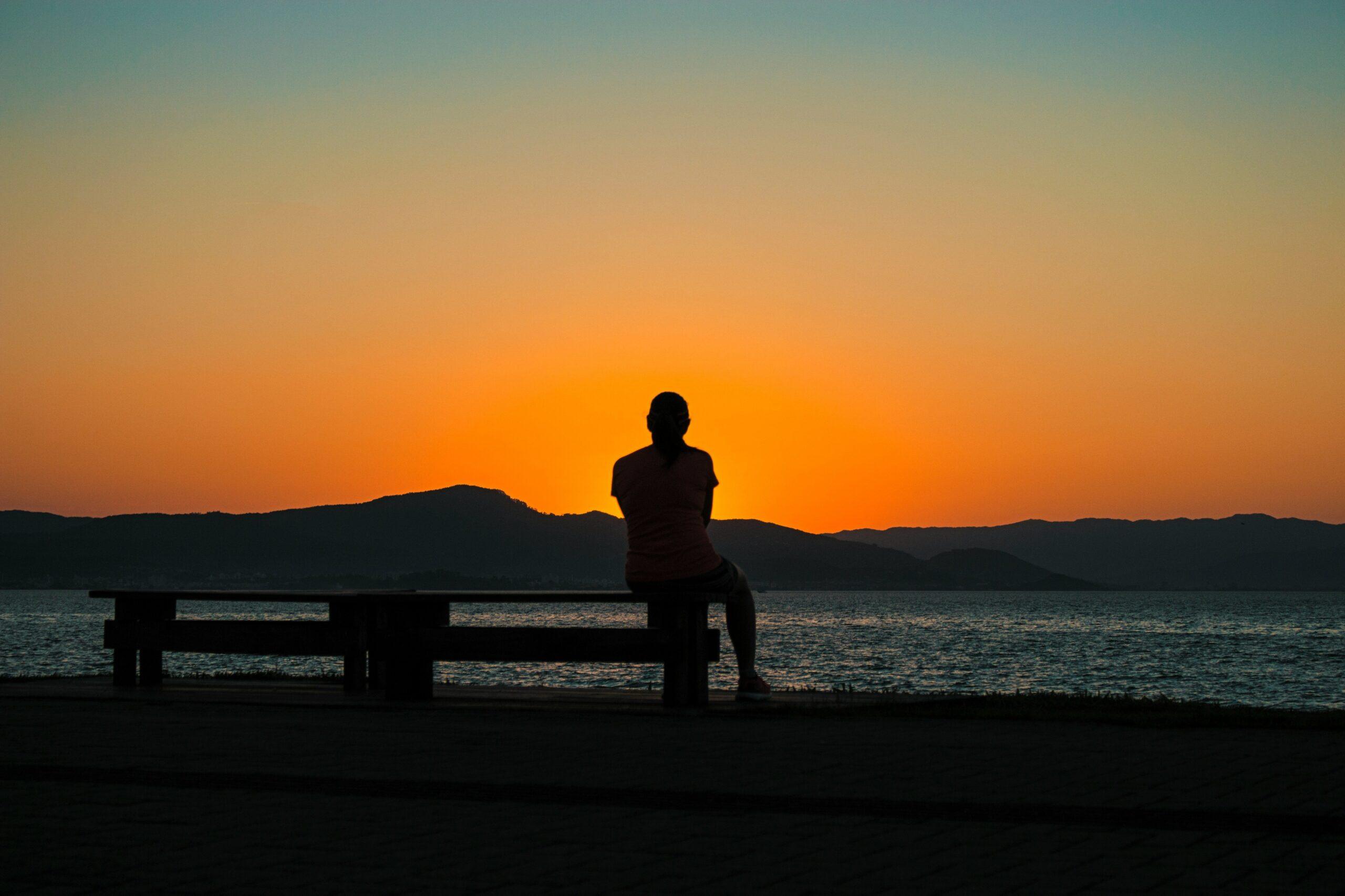 A person meditating next to their car during rush hour, symbolizing stress relief through mindfulness.