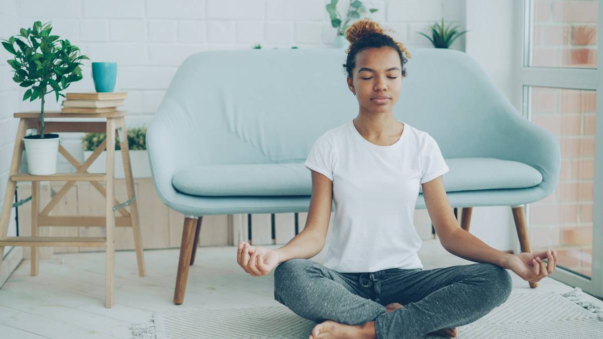 A serene illustration showing someone meditating with the Buddhify app open on their phone.